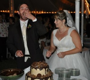 Alex chomps a piece of the grooms cake as Natalie looks on.