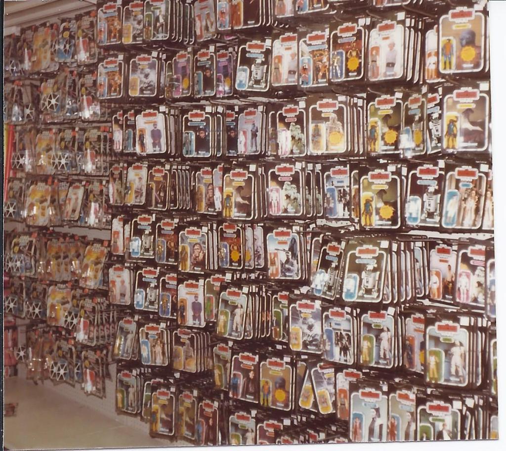 A wall of Star Wars movie action figure toys fill a wall.