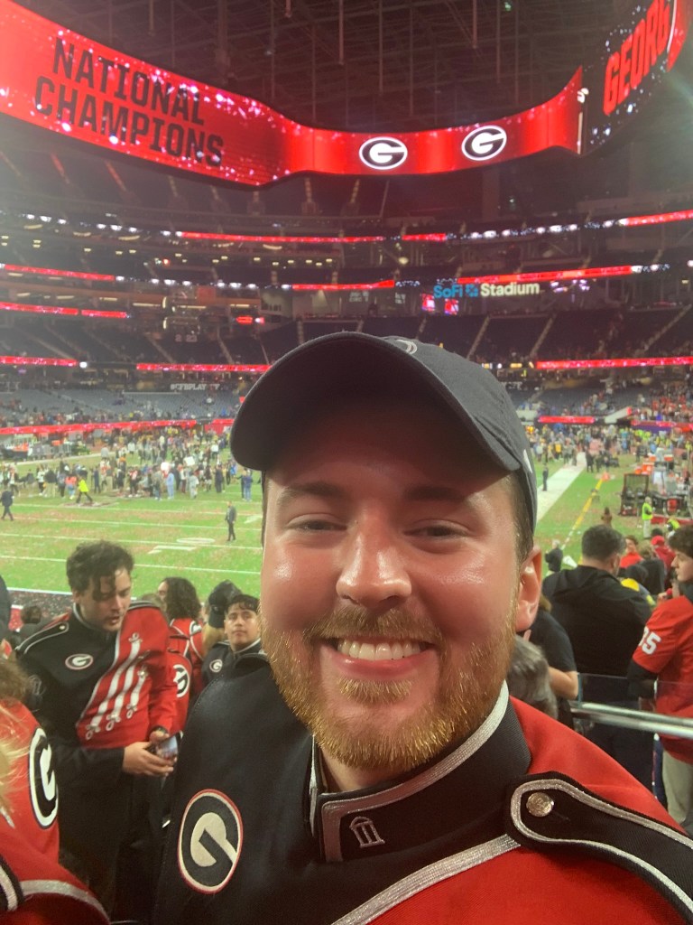 Barron Wallace grinning from ear to ear in his Redcoat marching band uniform at the 2023 college football National Championship game at SoFi Stadium in Los Angeles.