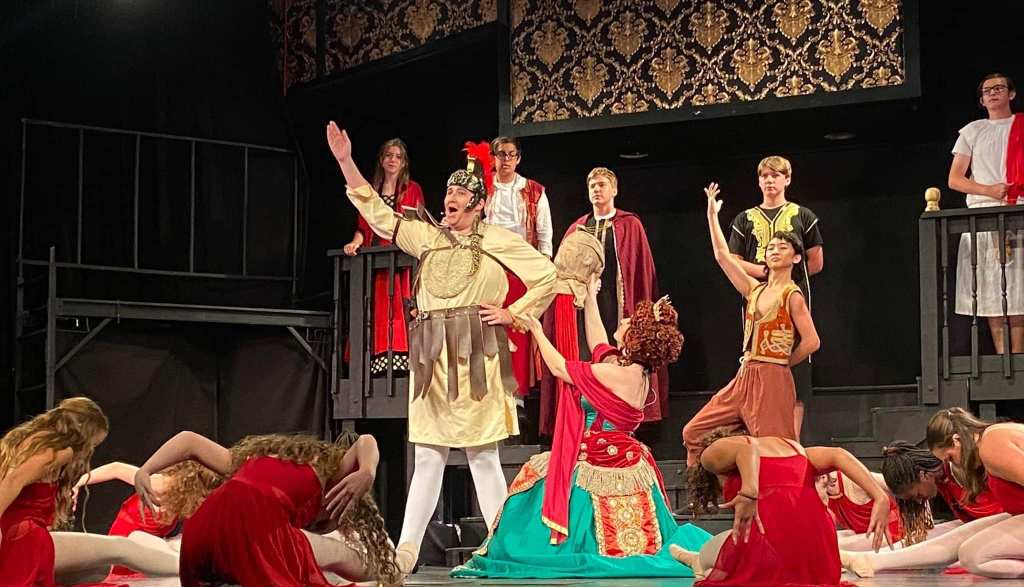 A teenager dressed as a Roman soldier singing on stage