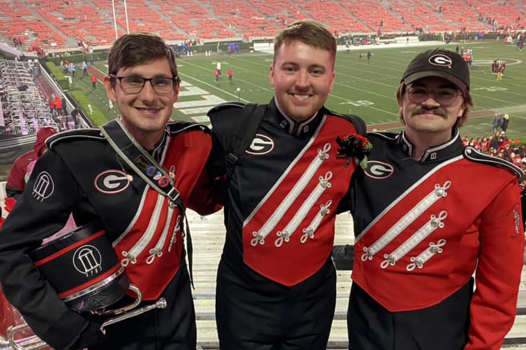 Three men in Redcoat Marching Band uniforms