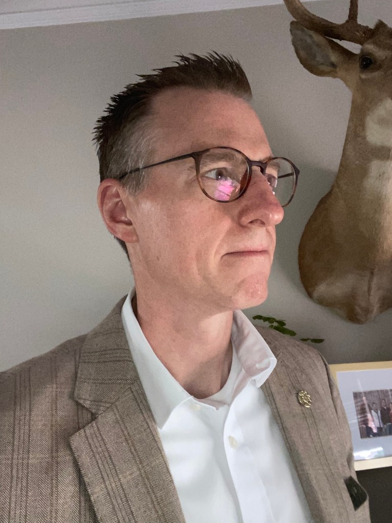 man in light brown plaid sports coat