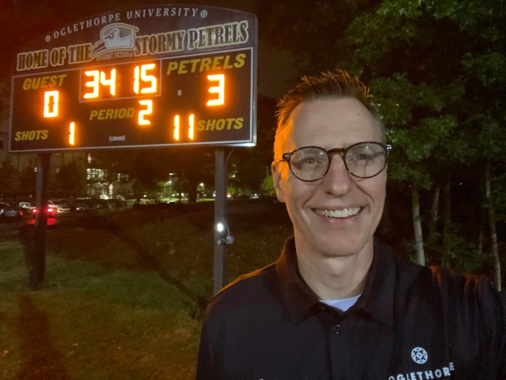 a man in front of scoreboard