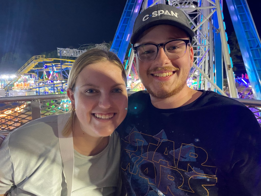 A young woman and a young man in a ferris wheel gondola