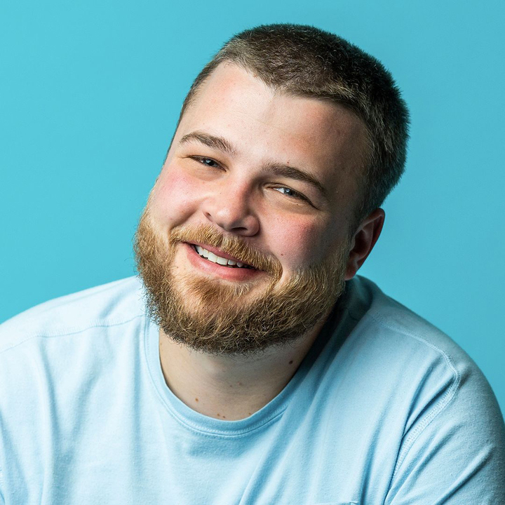 A man with a beard wearing a light blue T-shirt