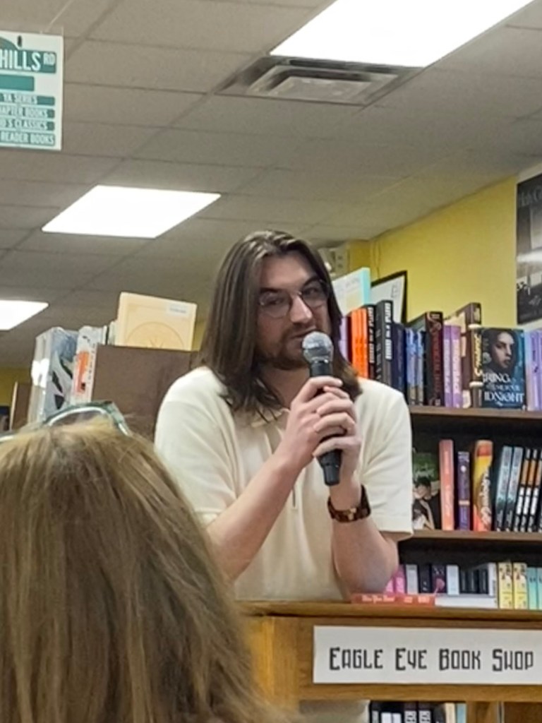 A man at podium in a bookstore