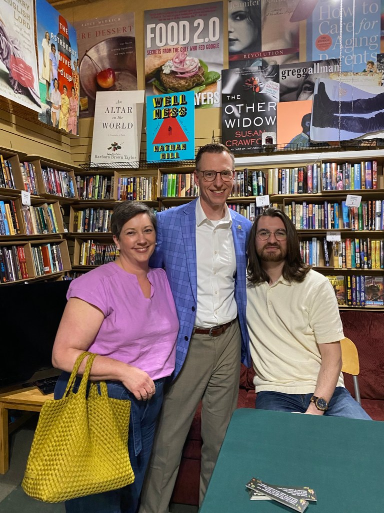 A woman and two men in a book store