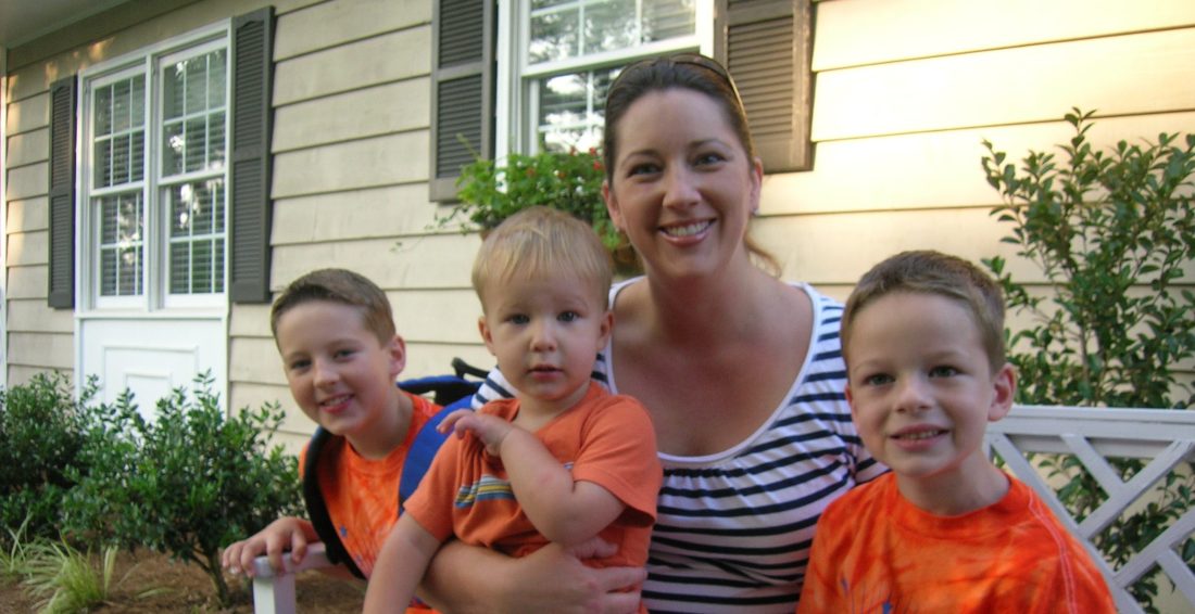 A mom on a bench with her three young sons