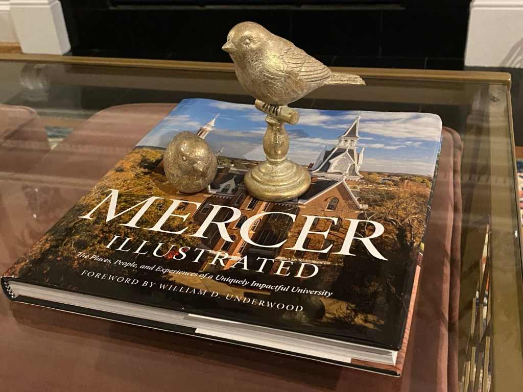 Mercer University photo book on a coffee table under two decorative bird figurines