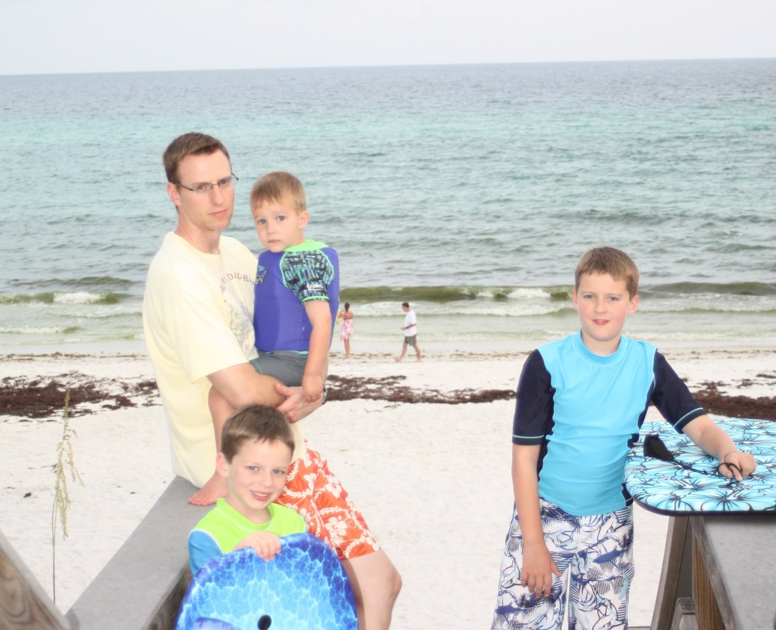 Three boys with their dad at the beach