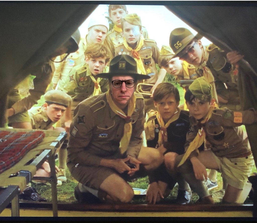 A scoutmaster and his scouts look into a tent. Lance's face is Photoshopped onto Edward Norton's body from the film, Moonrise Kingdom.