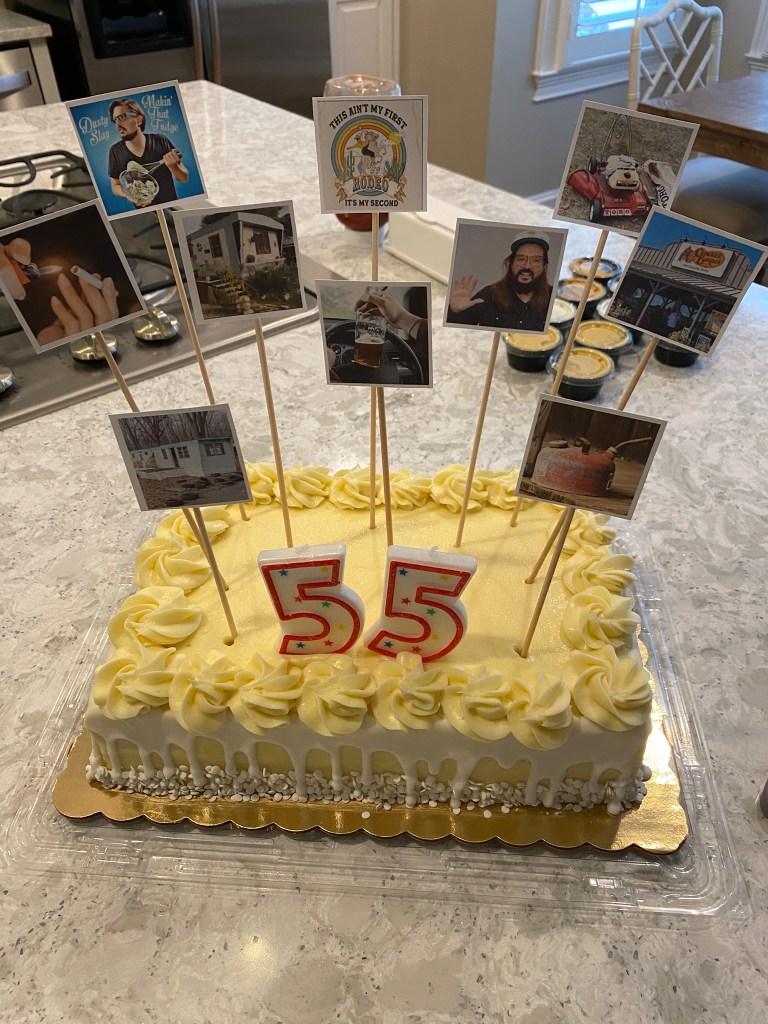 Birthday cake with images of Dusty Slay attached to wooden skewers sticking in it.