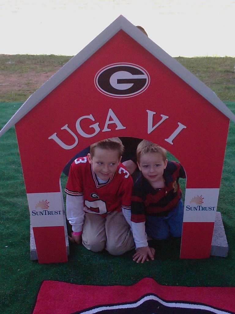 Two boys in a wooden doghouse for Georgia's mascot, Ugga.
