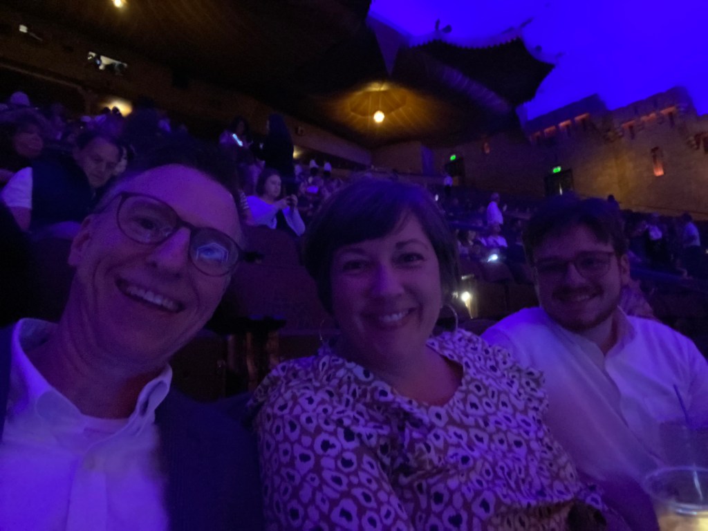 Three people in a darkened theater