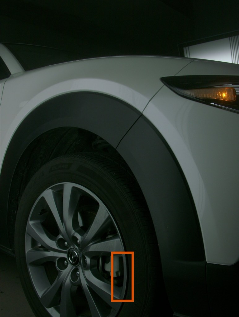 Photo of a tire with an orange box outlining a scratch on the rim