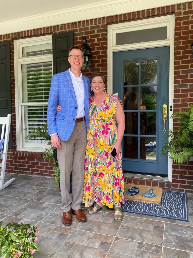 A man and woman stand on their porch
