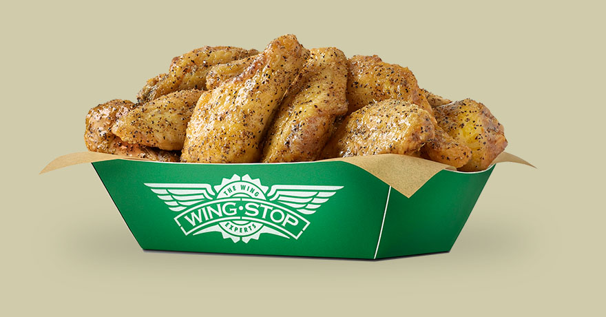 a green paper basket with the Wingstop logo on it filled with lemon pepper flavored chicken wings