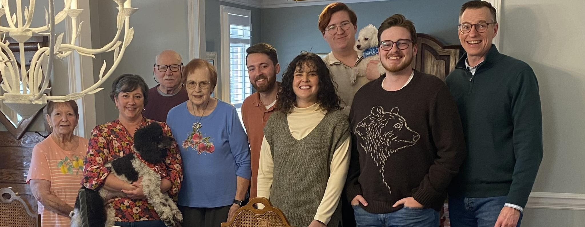 The Wallace family standing behind the Thanksgiving table