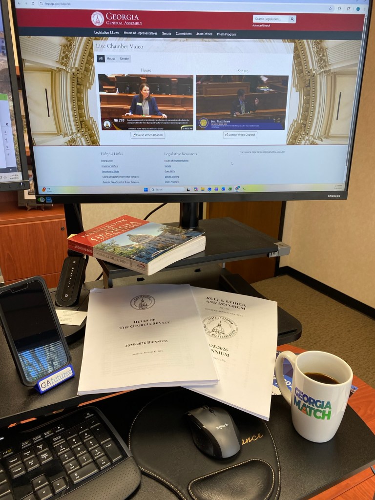 A computer monitor with the video feed from the Georgia House of Representatives and Senate side-by-side on the screen.