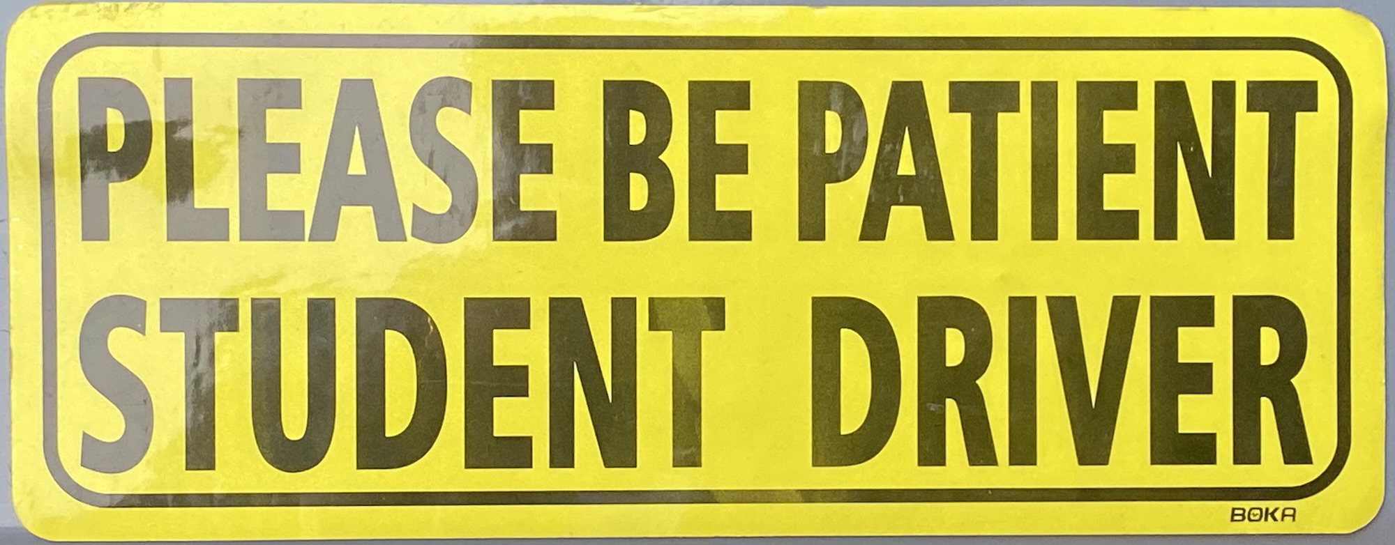 yellow car magnet that says "Please be patient student driver"