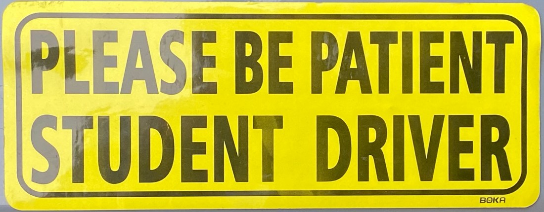yellow car magnet that says "Please be patient student driver"