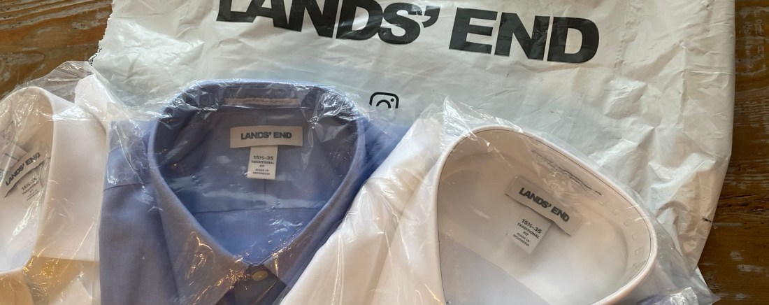 Packages of blue and white dress shirts laid out on a Land's End package.