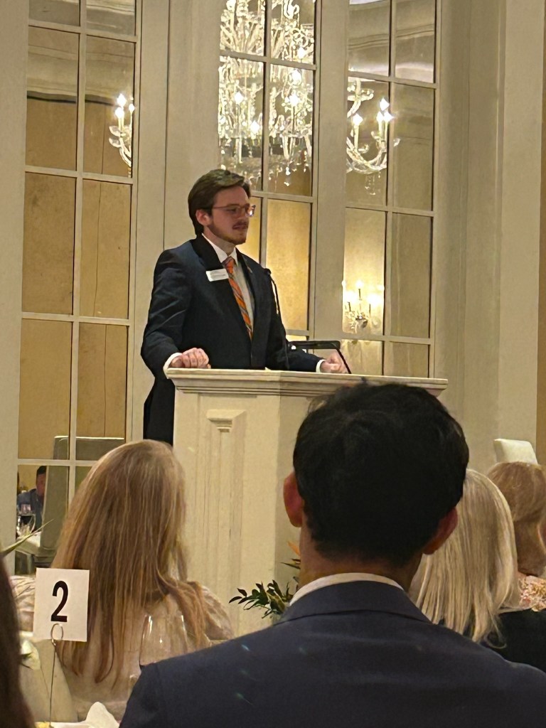 A young man in a suit and tie at a podium