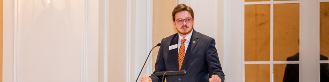 A young man in a suit in tie at a podium