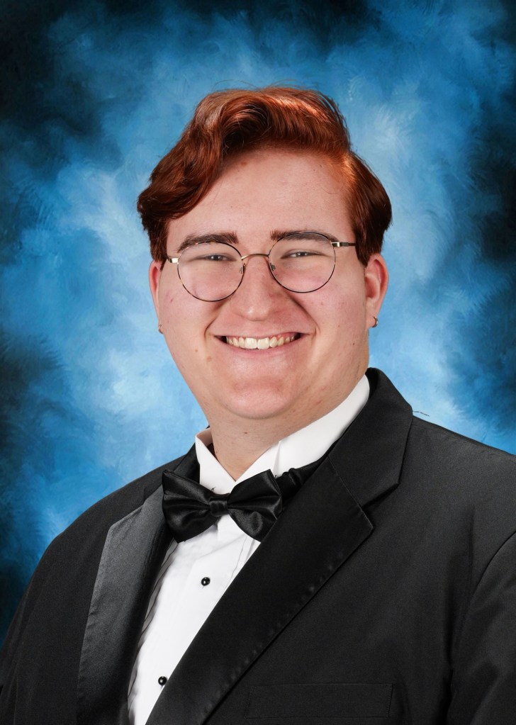 A red-haired teenager in a tuxedo