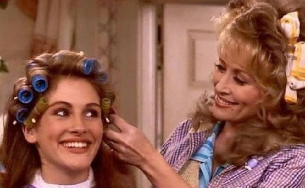 A hairdresser putting a woman's hair in curlers