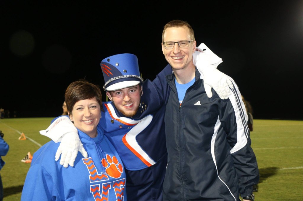 Two parents with a marching band member