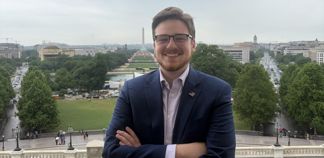 A young man in Washington, D.C., with the Washington Monument and the National Mall in the background