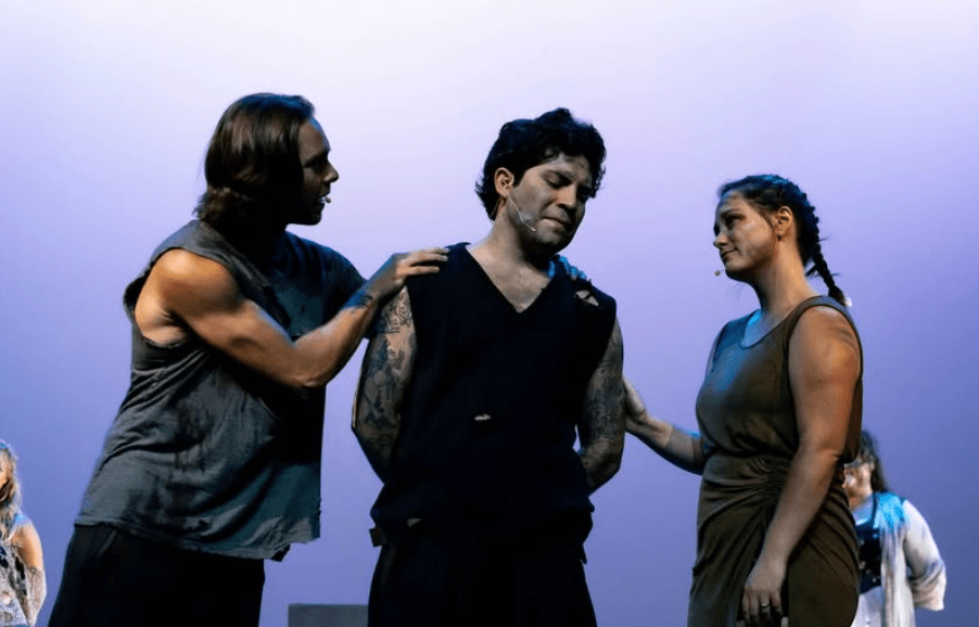 A man and woman comfort a man on stage