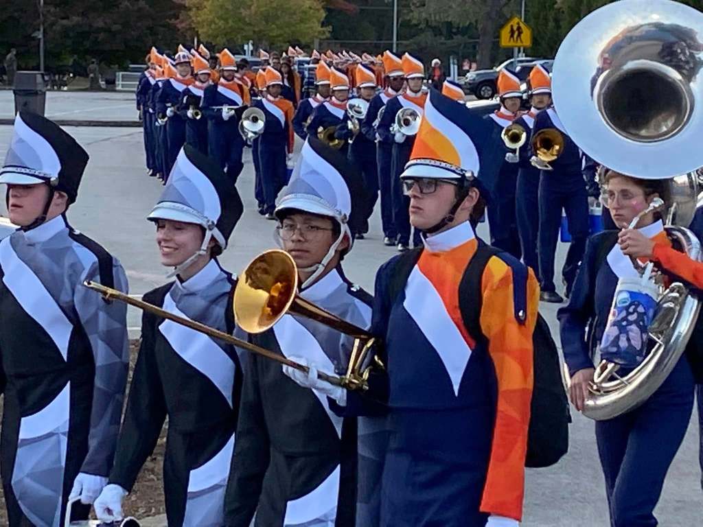 A high school marching band marches into the stadium