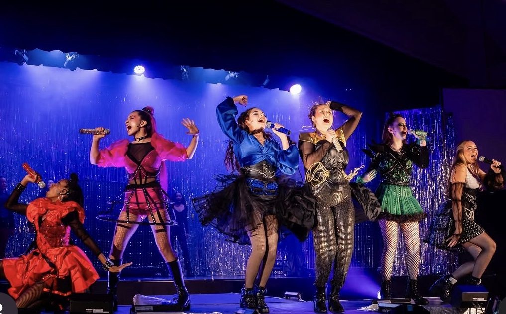 Teenage girls sing on stage