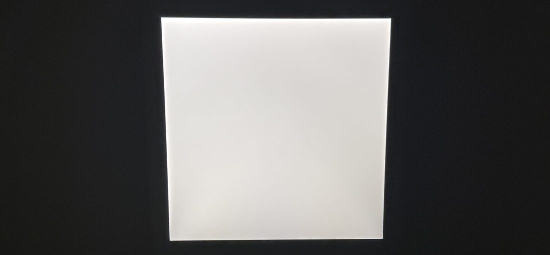 A square light in the middle of a dark ceiling.