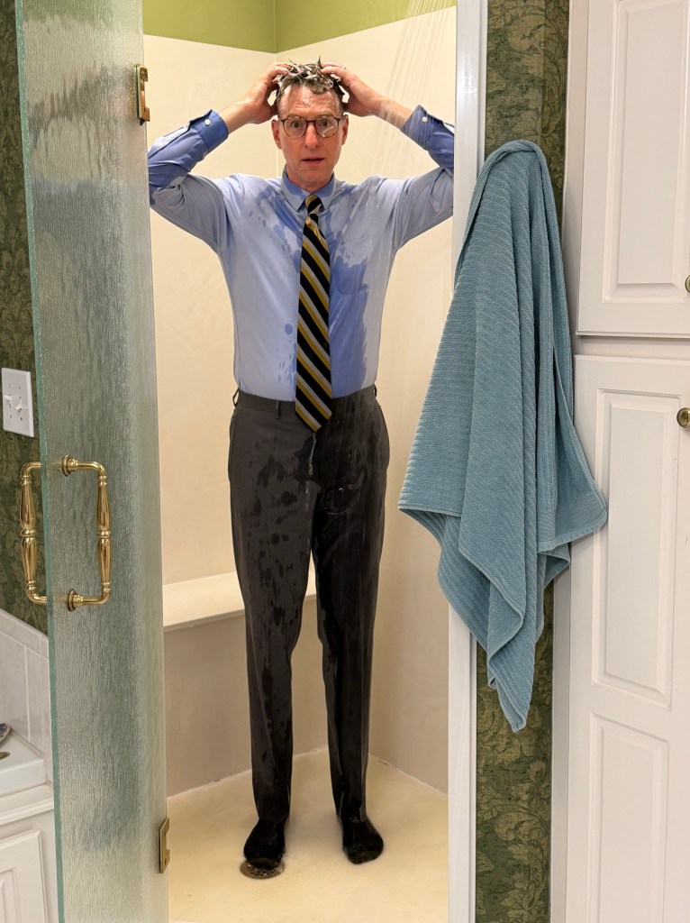 A man washes his hair in a shirt and tie