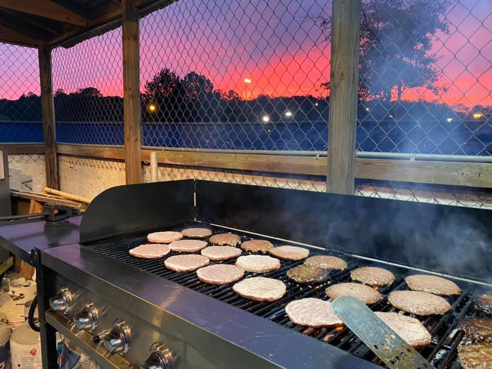 Grill loaded with burger patties at sunset