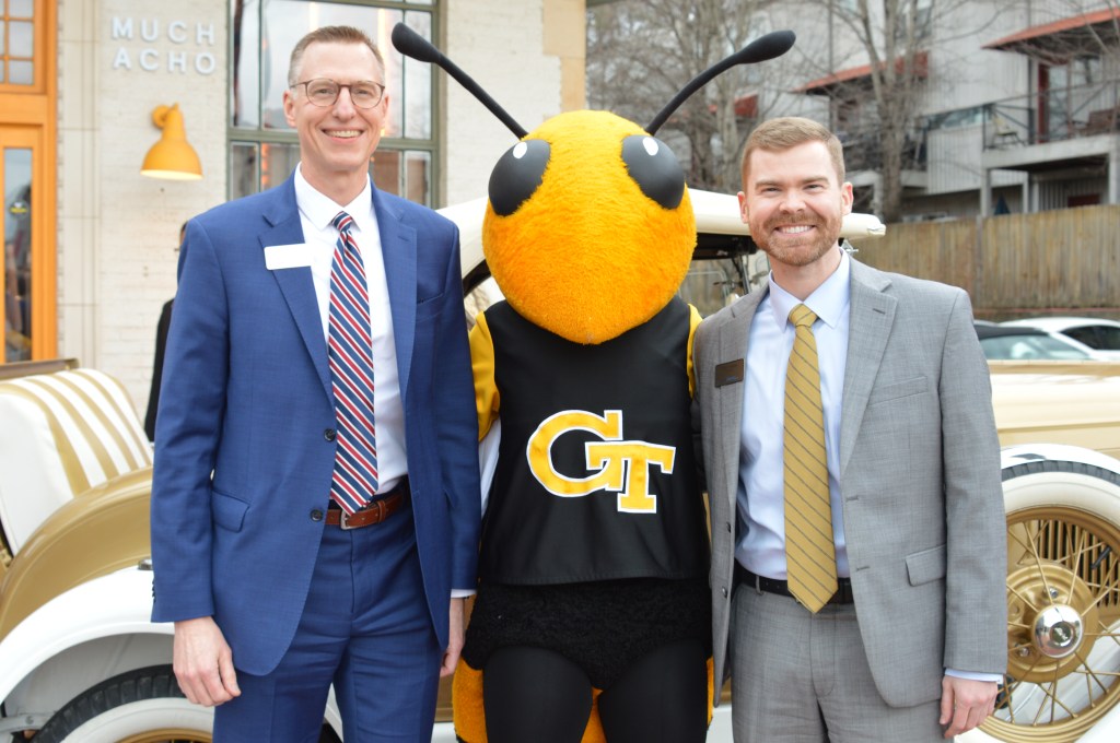 Two men in suits with Georgia Tech's mascot Buzz