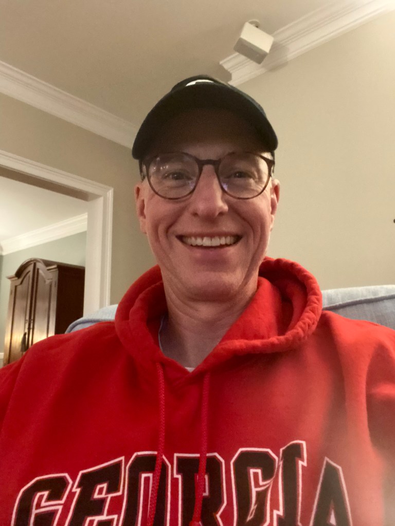 A man in a University of Georgia ball cap and hoodie