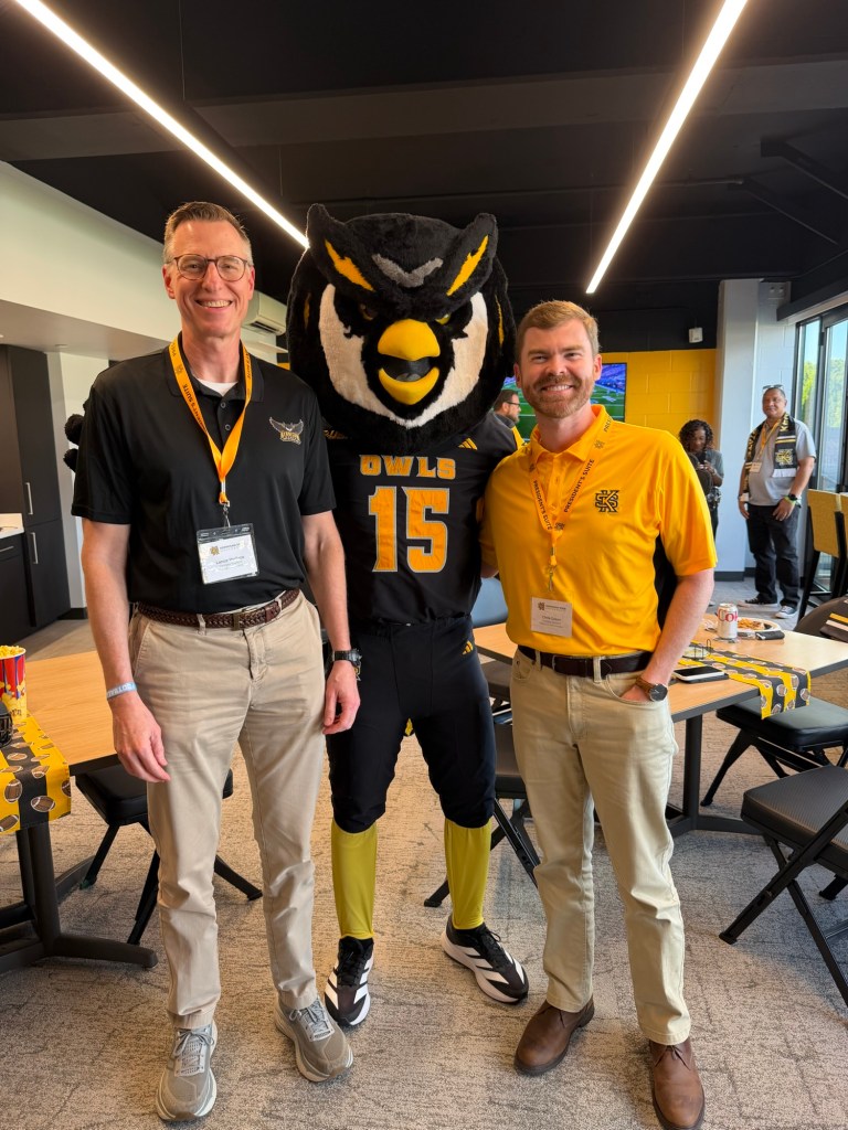 Two men with Kennesaw State University's mascot Scrappy the Owl