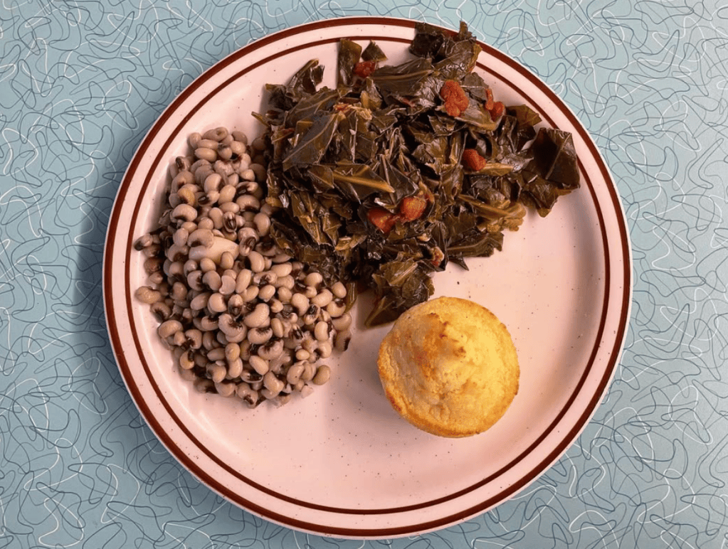 Plate with black eyed peas, collard greens and cornbread.
