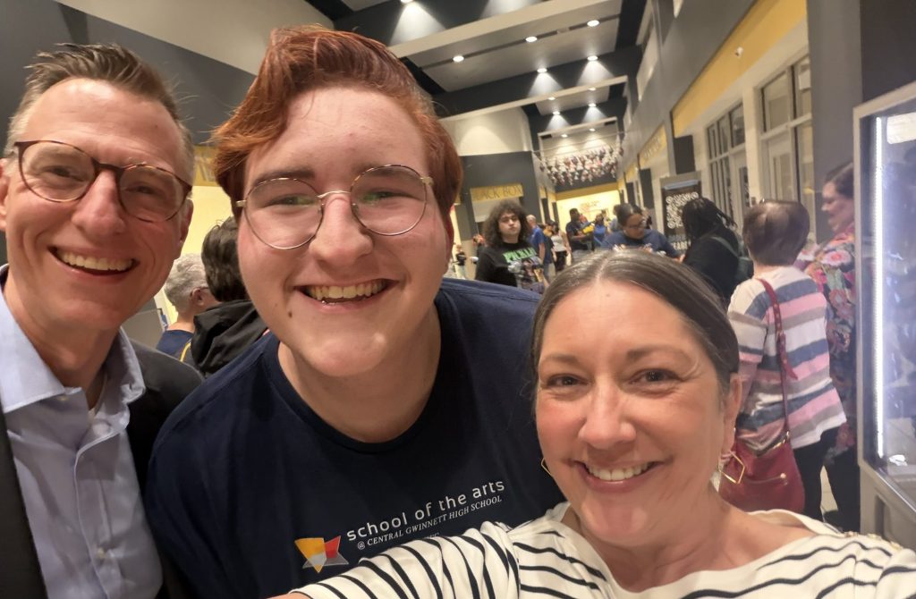A selfie of two parents and their adult soon