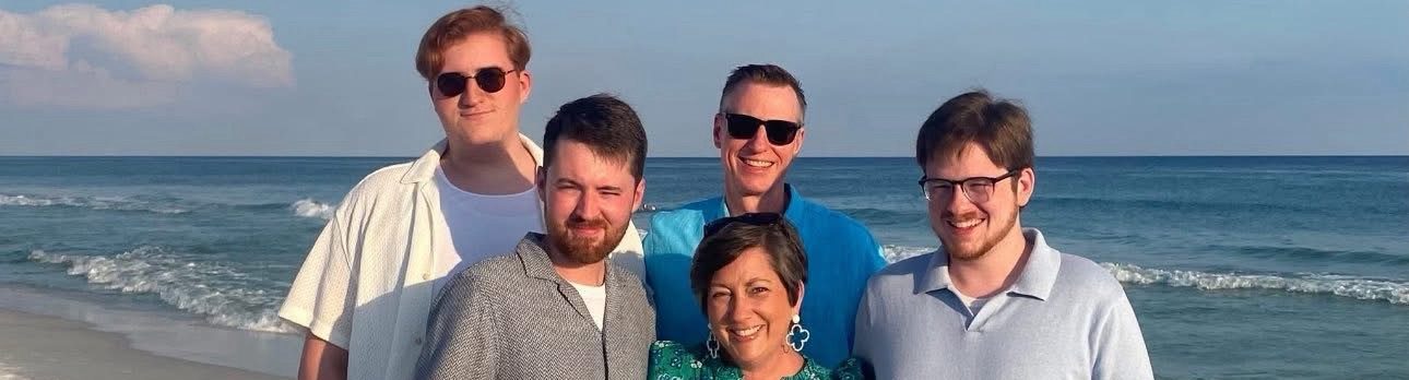 A husband, wife and three adult sons on the beach