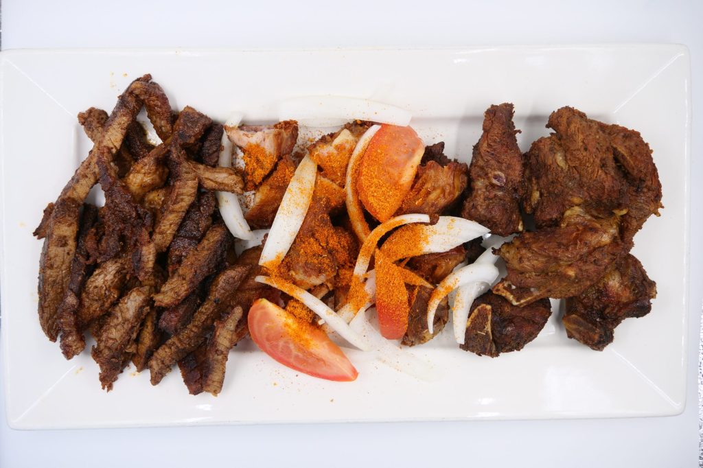 plate with brisket, onions, yaji spices and goat meat